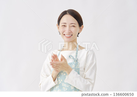 一位身穿圍裙的女子在白色背景上鼓掌 136600650