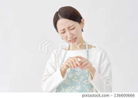 一位穿著圍裙、雙手皸裂的女子，白色背景 136600666
