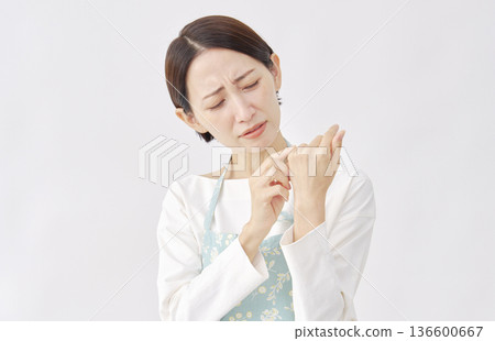 Woman wearing an apron with chapped and cracked hands, white background Woman wearing an apron with chapped and cracked hands, white background 136600667