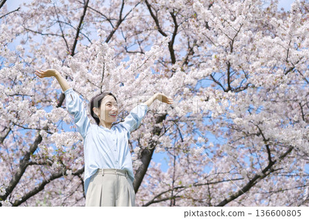 A woman stretching in front of cherry blossoms A woman stretching in front of cherry blossoms 136600805