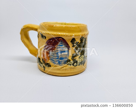Vintage style brown ceramic cup with textured village motif Vintage style brown ceramic cup with textured village motif 136600850