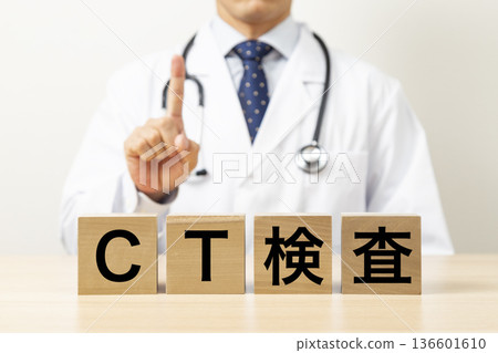一塊寫著「CT掃描」字樣的磚塊,旁邊站著一位醫生 一塊寫著「CT掃描」字樣的磚塊,旁邊站著一位醫生 136601610