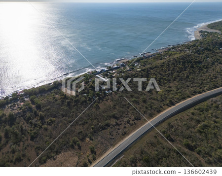Coastal road along the shoreline near a small town by the sea Coastal road along the shoreline near a small town by the sea 136602439