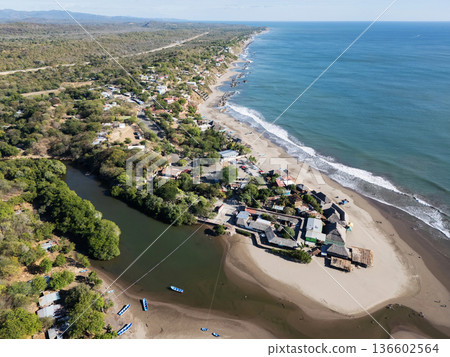 View of a coastal village along the shoreline and river in daylight 136602564