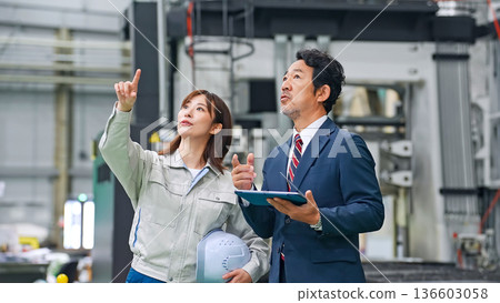 Businessman and worker inspecting a factory 136603058