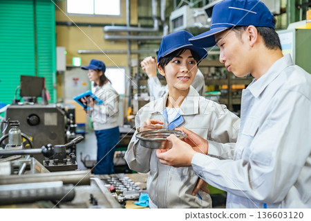 A group of workers operating machine tools in a factory 136603120