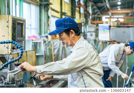 一名男工人在工廠操作機器 136603147