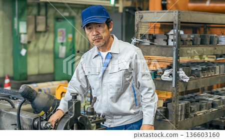Male worker operating a machine in a factory Male worker operating a machine in a factory 136603160