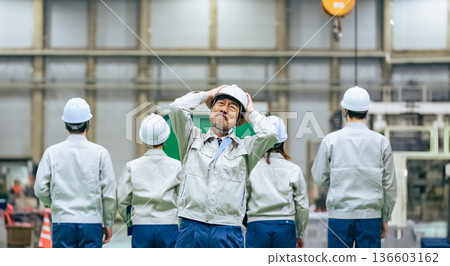 A worker leader is shocked when his subordinates turn their backs on him in a factory A worker leader is shocked when his subordinates turn their backs on him in a factory 136603162