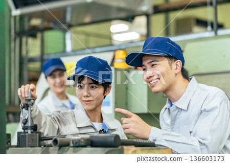 Group of workers operating machines in a factory Group of workers operating machines in a factory 136603173