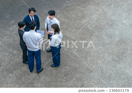 Group of office workers gathered outdoors to talk 136603179