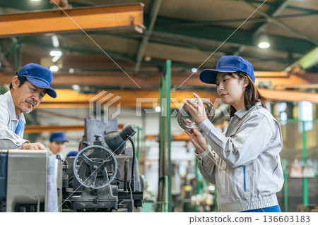 A group of workers inspecting products in a factory A group of workers inspecting products in a factory 136603183