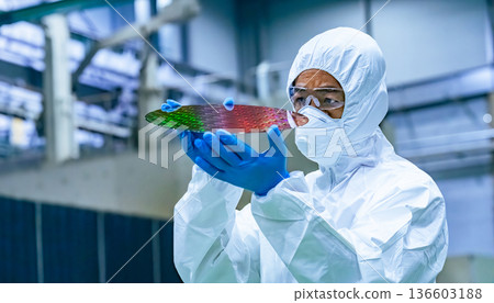 半導體工廠內身穿防護衣的男工人檢查矽片 136603188