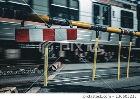 鐵路道口欄桿和駛過的列車 鐵路道口欄桿和駛過的列車 136603235