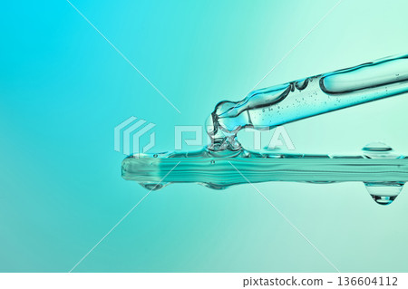 Pipette dropper applying cosmetic serum liquid to a surface Pipette dropper applying cosmetic serum liquid to a surface 136604112