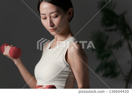 用啞鈴訓練肌肉的女性 用啞鈴訓練肌肉的女性 136604420