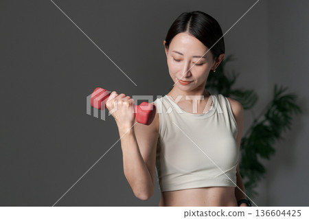 用啞鈴訓練肌肉的女性 用啞鈴訓練肌肉的女性 136604425