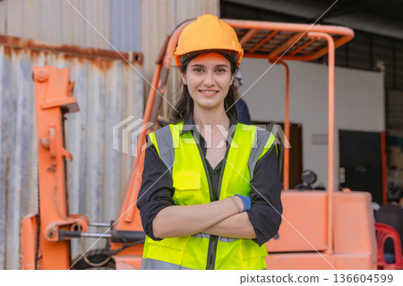 Woman worker at forklift driver happy working in industry factory logistic ship. 136604599