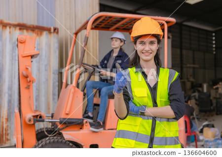 Woman worker at forklift driver happy working in industry factory logistic ship. 136604600