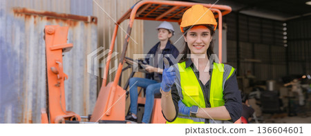 Woman worker at forklift driver happy working in industry factory logistic ship. Woman worker at forklift driver happy working in industry factory logistic ship. 136604601