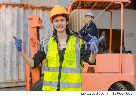 Woman worker at forklift driver happy working in industry factory logistic ship. 136604602