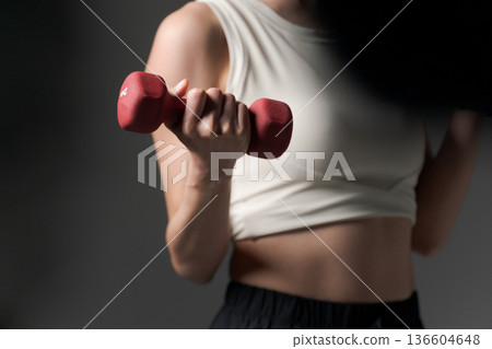 Part cut of a woman doing muscle training with dumbbells Part cut of a woman doing muscle training with dumbbells 136604648
