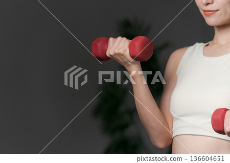 一段女性使用啞鈴進行肌肉訓練的片段 136604651
