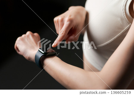 一位身穿運動服的女士正在看智慧手錶 136605259