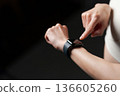 A woman in sportswear looking at a smartwatch 136605260