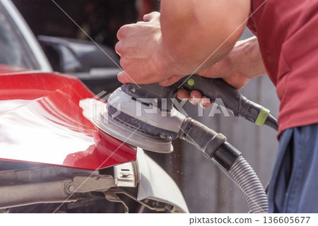 Repairing car body by puttying close up work after the accident by working sanding primer before painting. , The mechanic repair the car. 136605677