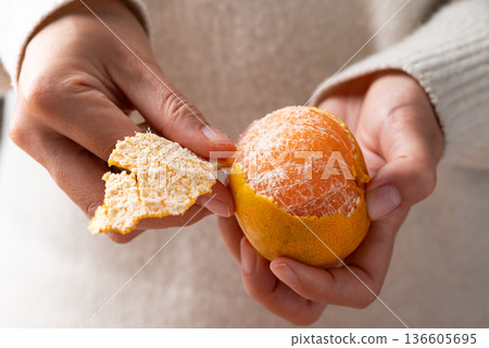 Mandarin orange fruit peeling by hand and eating 136605695
