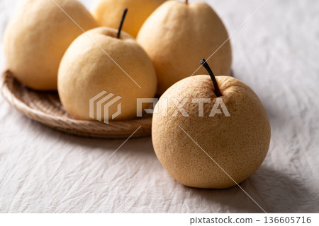 Fresh Asian pears on white wrinkled fabric with soft natural light 136605716
