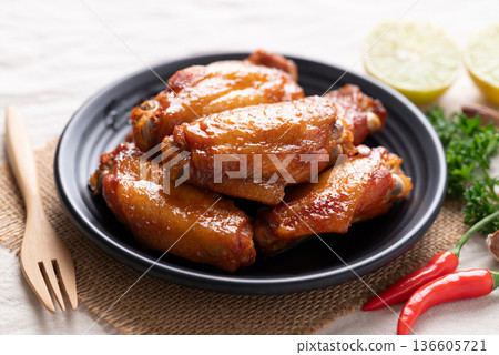 Grilled New Orleans chicken wings on a black plate with a fork Grilled New Orleans chicken wings on a black plate with a fork 136605721