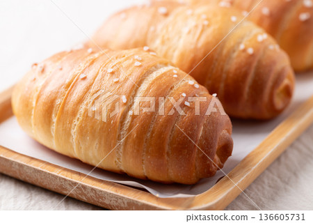 Salt bread (Shio pan) with sea salt flakes on a wooden plate, Japanese bakery style Salt bread (Shio pan) with sea salt flakes on a wooden plate, Japanese bakery style 136605731