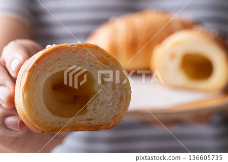 Salt bread (Shio pan) with sea salt flakes holding by woman hand and eating, Japanese bakery style Salt bread (Shio pan) with sea salt flakes holding by woman hand and eating, Japanese bakery style 136605735