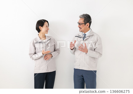 Men and women talking while wearing work clothes Men and women talking while wearing work clothes 136606275