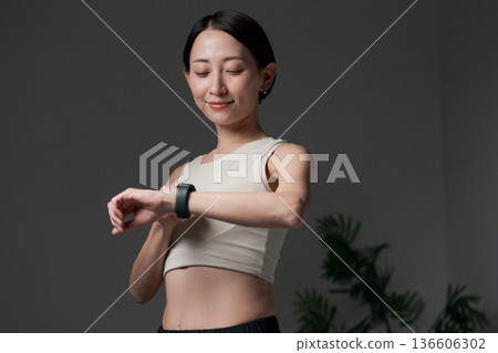 一名正在進行肌肉訓練的女子正在看智慧手錶 136606302