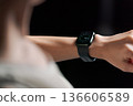 A woman in sportswear wearing a smartwatch 136606589