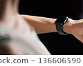 A woman in sportswear wearing a smartwatch 136606590