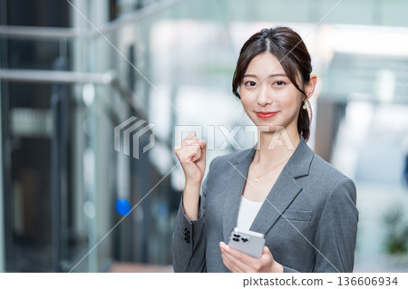 A career woman operating a smartphone A career woman operating a smartphone 136606934