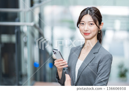 一位職業婦女正在操作智慧型手機 136606938