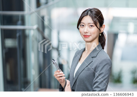 一位職業婦女正在操作智慧型手機 一位職業婦女正在操作智慧型手機 136606943