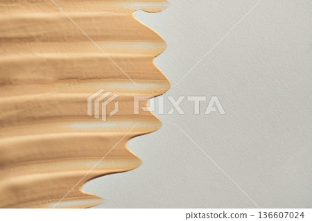 Beige liquid foundation creating textured smeared swatch on light background Beige liquid foundation creating textured smeared swatch on light background 136607024