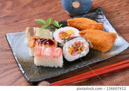 An assortment of inari sushi, inari sushi, thick rolls, and pressed sushi. An assortment of inari sushi, inari sushi, thick rolls, and pressed sushi. 136607412