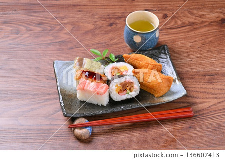 An assortment of inari sushi, inari sushi, thick rolls, and pressed sushi. An assortment of inari sushi, inari sushi, thick rolls, and pressed sushi. 136607413