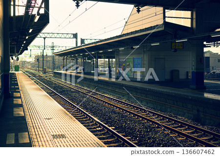 A station platform bathed in the afternoon sun 136607462
