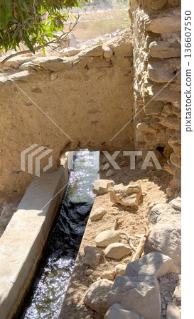 Rural Farmer Maintains Ancient Water Delivery Under Bright Sunlight. Resilient Rural Irrigation Setup With Farmer Tending To Classic Water Flow System In Sunlight Rural Farmer Maintains Ancient Water Delivery Under Bright Sunlight. Resilient Rural Irrigation Setup With Farmer Tending To Classic Water Flow System In Sunlight 136607550
