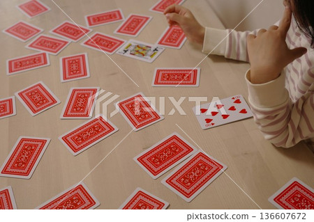 A child struggling to think of the next card in a deck of cards 136607672