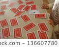 A child turns over the ace of clubs in a deck of cards 136607780