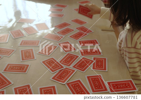 A child seriously choosing a playing card A child seriously choosing a playing card 136607781